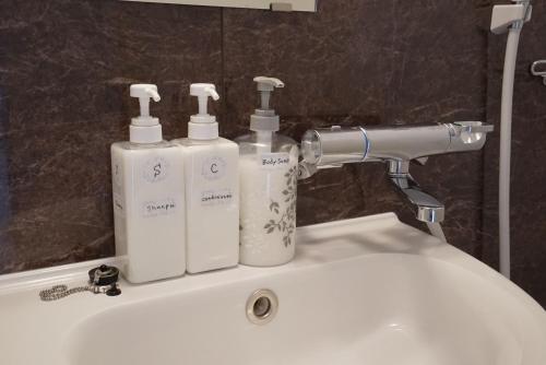 a bathroom sink with two soap bottles on it at Villa Feliz 101 in Tomari
