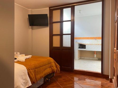 um quarto com uma cama e uma porta de vidro deslizante em VILLA VICTORIA em Chachapoyas
