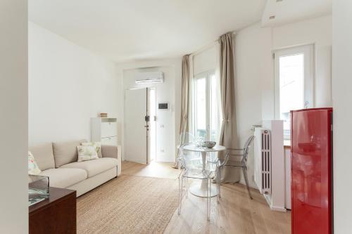 Sala de estar blanca con sofá y mesa en Casa Serena - Meryggiare Apartments, en Milán