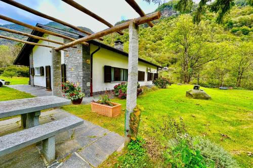 a house with a grass yard with a yard at Casa Mima Chalets in Gerra Verzasca