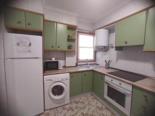 eine Küche mit grünen Schränken und einer Waschmaschine in der Unterkunft Típico apartamento de pueblo in Faura