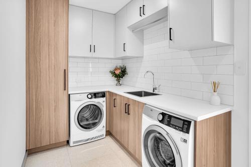 a kitchen with a washing machine and a sink at Simply Stunning Holiday Views! in Legana