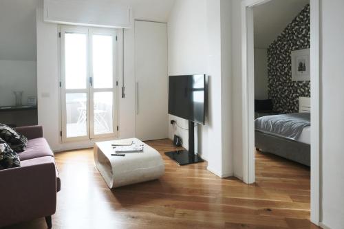 a living room with a couch and a tv at ComeCasa Prestigioso Attico in Duomo - San Babila in Milan