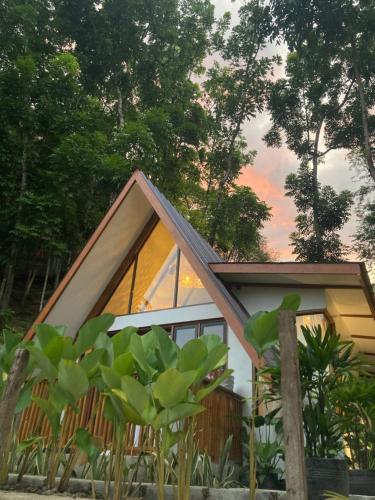 a small house with a glass facade and trees at Casa Maria at Bigang Munti in San Juan