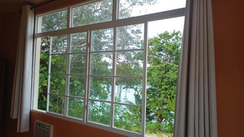 a window with a view of a tree at Boca Chica BnB at Gone Fishing Panama Resort in Boca Chica