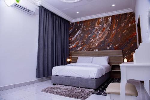 1 dormitorio con 1 cama y una pintura en la pared en PINORICH VILLA-Buea, en Buea