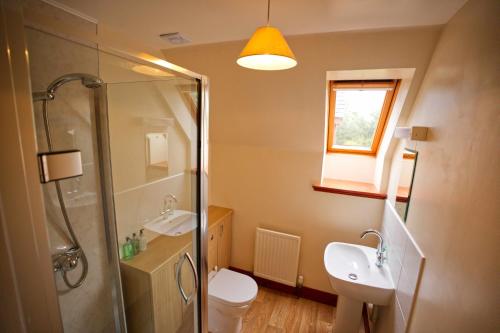 a bathroom with a shower and a toilet and a sink at Woodlands House in Ballachulish