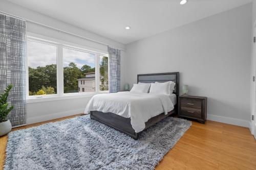 a white bedroom with a bed and a window at King Bed-Fireplace-15 min to DT-220 EVPlug in Asheville