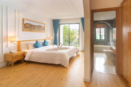 um quarto com uma cama grande e uma casa de banho em Lime villa em Hoi An