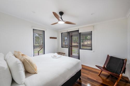 a bedroom with a bed and a ceiling fan at Farmstay -LJHooker Yamba in Maclean