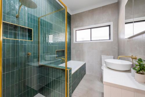 a bathroom with a sink and a glass shower at Farmstay -LJHooker Yamba in Maclean