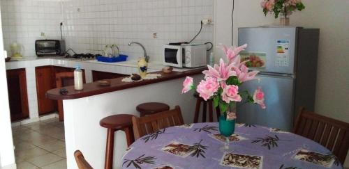 une cuisine avec une table et un vase de fleurs. dans l'établissement LE ZAGOUTI, à Capesterre