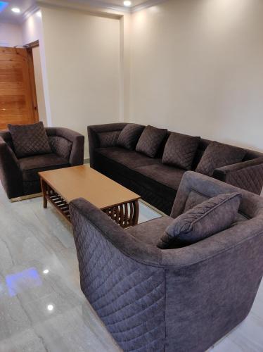 - un salon avec deux canapés et une table dans l'établissement Superb Luxury Three Bed Apartment, à Shimla
