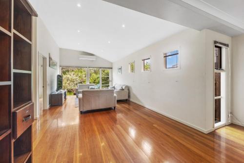 an empty living room with wooden floors and white walls at Surf View - WiFi Included in Inverloch