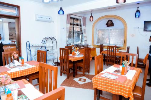 un restaurante con mesas y sillas de madera y una ventana en Port Park Hotel, en Mwanza