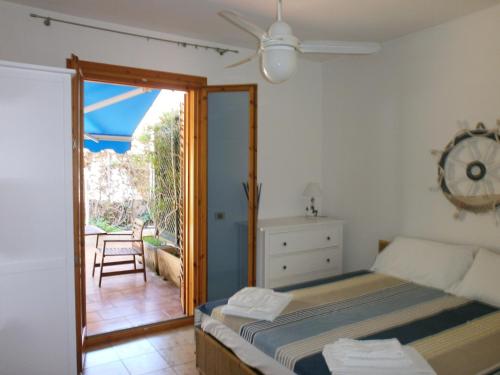 マリーナ・ディ・ラグーザにあるIl Favolloのベッドルーム1室(ベッド1台付)、パティオへのドアが備わります。