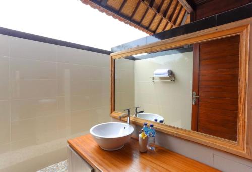 a bathroom with a sink and a mirror at Island Cabanas Formerly Taman Sari Villa in Nusa Lembongan