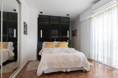 1 dormitorio con 1 cama grande con almohadas amarillas en Fliphaus Gurruchaga 2300 - 1 Bd Palermo Soho en Buenos Aires