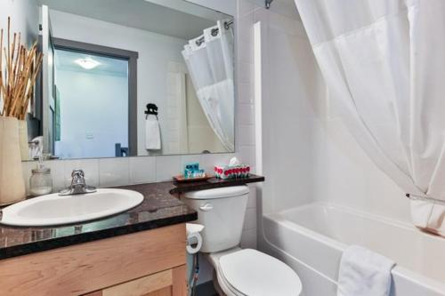 a bathroom with a sink and a toilet and a bath tub at Mystic Chalet hosted by Fenwick Vacation Rentals in Canmore