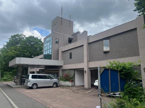 a car parked in a parking lot in front of a building at フューデイズコンドミニアム定山渓206号室 in Jozankei