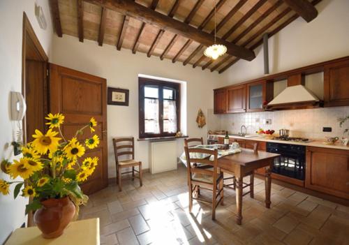 eine Küche mit einem Tisch und Stühlen sowie ein Esszimmer in der Unterkunft Agriturismo Bellarosa in Assisi