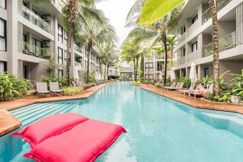 una piscina in un hotel con palme di Diamond Condo by VС a Bang Tao Beach