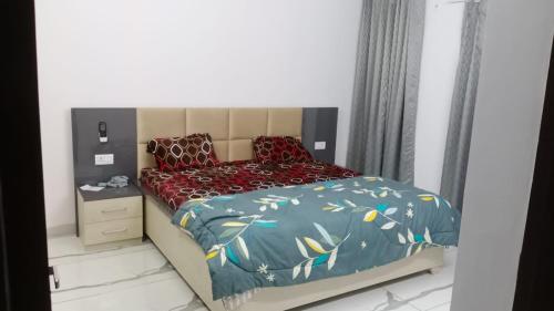 una piccola camera da letto con un letto e un piumone blu di Sindhu Villa a Lucknow
