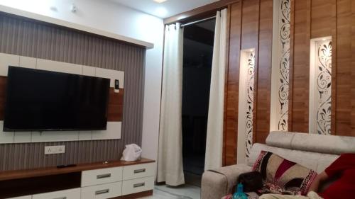 a living room with a television on a wall at Sindu Villa in Lucknow