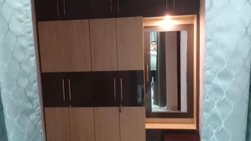 a wooden cabinet with a mirror in a bathroom at Sindu Villa in Lucknow