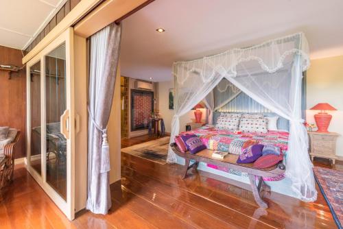 a bedroom with a bed with a canopy at Kanlaya's Eyrie, Luxury Homestay in Pang Mapha