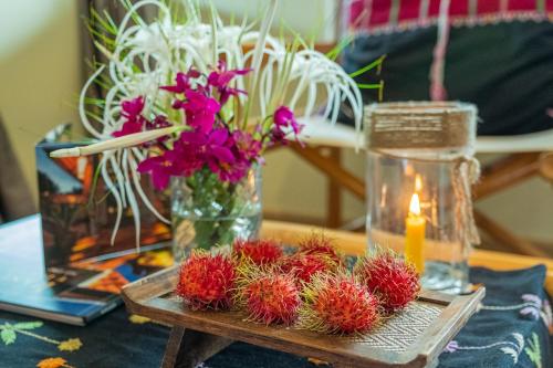 a table with flowers and a candle on a table at Kanlaya's Eyrie, Luxury Homestay in Pang Mapha