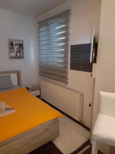 ein Schlafzimmer mit einem gelben Bett und einem Fenster in der Unterkunft Apartman Park Kragujevac in Kragujevac
