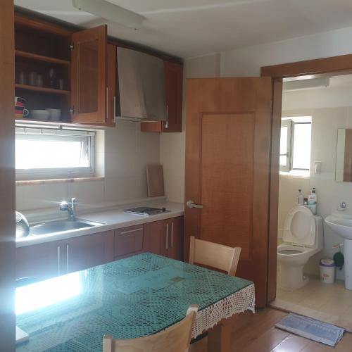 uma cozinha com uma mesa, um lavatório e um WC em Gutenberg house em Namhae