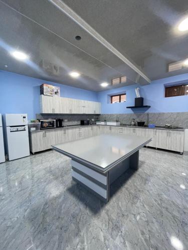 eine große Küche mit einem Tisch in der Mitte in der Unterkunft IMAM AZAM HOTEL in Samarkand