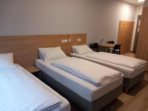 a hotel room with two beds and a table at Centrum Szkoleniowo - Noclegowe HHM HEGELMANN o Zgorzelec in Zgorzelec