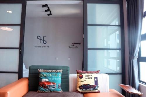 a room with a couch with a book and a suitcase at Homesuite' Home at Jesselton Quay in Kota Kinabalu
