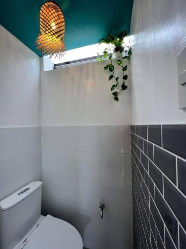 a bathroom with a toilet and a fluorescent light at 11th Earth Farm and Resort in Nabua