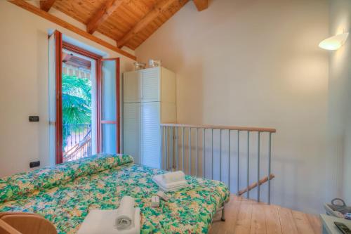 a small bedroom with a bed and a window at La Piccola Casa Dell'Uva Fragola - Happy Rentals in Meina