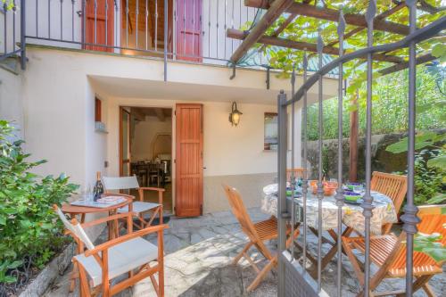 a patio with a table and chairs and a balcony at La Piccola Casa Dell'Uva Fragola - Happy Rentals in Meina