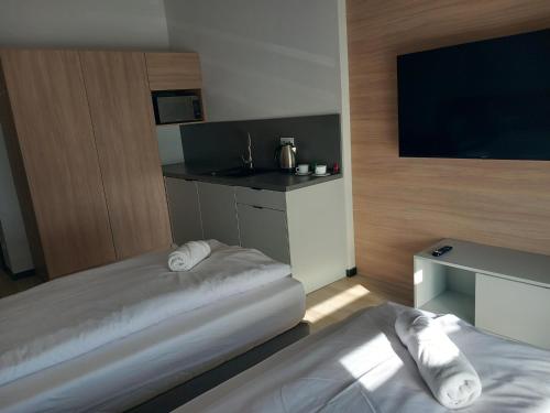 a hotel room with two beds and a flat screen tv at Centrum Szkoleniowo - Noclegowe HHM HEGELMANN o Zgorzelec in Zgorzelec
