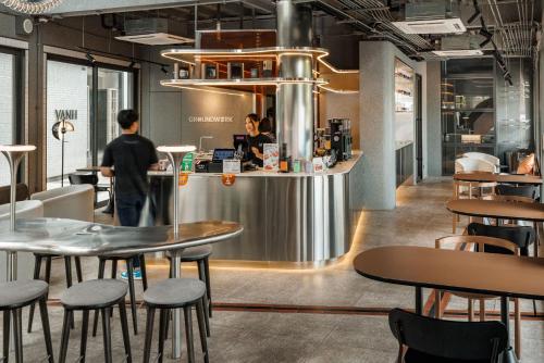 a restaurant with tables and people standing at a counter at YANH Ratchawat Hotel in Bangkok