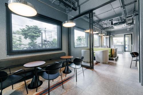 a room with two tables and chairs and windows at YANH Ratchawat Hotel in Bangkok