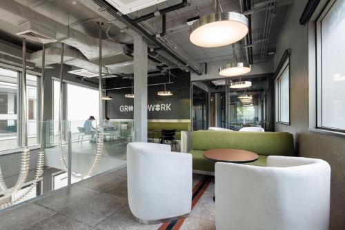 a lobby with a green couch and white chairs at YANH Ratchawat Hotel in Bangkok