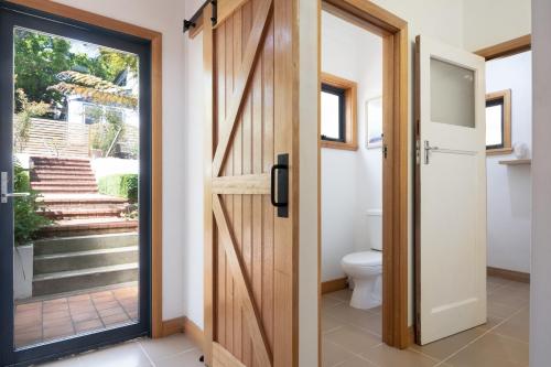 a bathroom with a wooden door and a toilet at Fun For the Whole Family in Alanvale