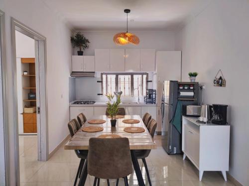 een keuken met een houten tafel en stoelen in een kamer bij Mon petit paradis in Flic-en-Flac