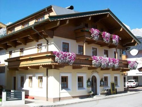 a building with flowers on the side of it at Wirtshäusl Maria Alm in Maria Alm am Steinernen Meer