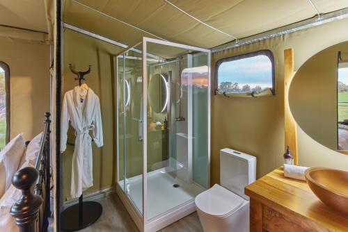 a bathroom with a shower and a sink at Willow Wood Glamping Retreat in Broadwater