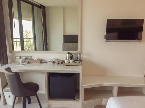 a room with a desk with a chair and a mirror at Sand Dunes Chaolao Beach Resort in Chao Lao Beach