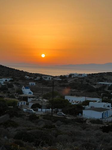 a sunset over a small town with white buildings at Alexandra’s studios in Iraklia