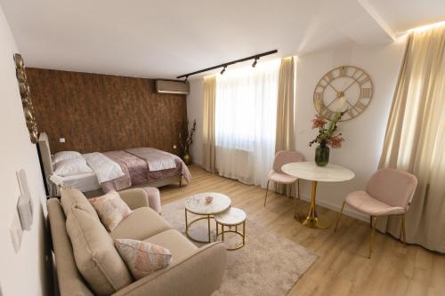Habitación de hotel con cama y sala de estar. en Soho Boutique Apartman en Požega